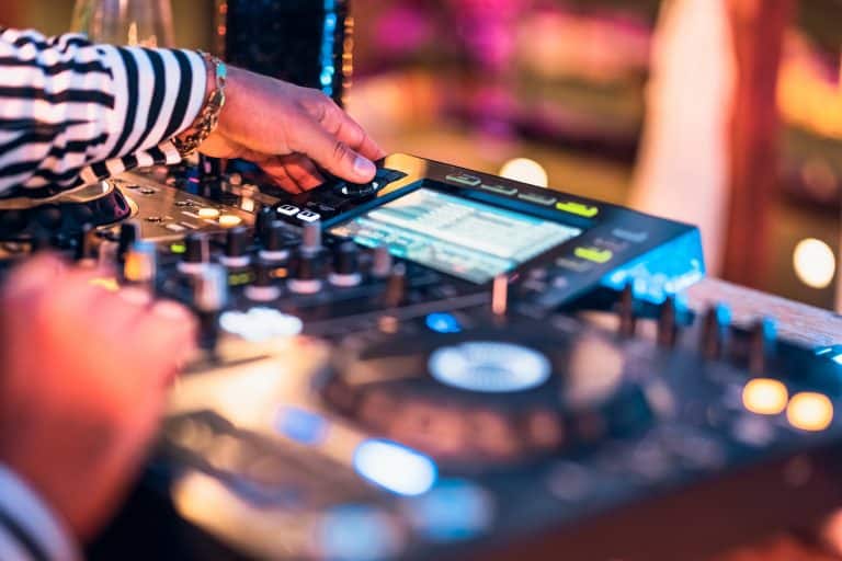 Cerrar la mano de dj mezclando música en el bar de cócteles - Concepto de vida nocturna de fiesta