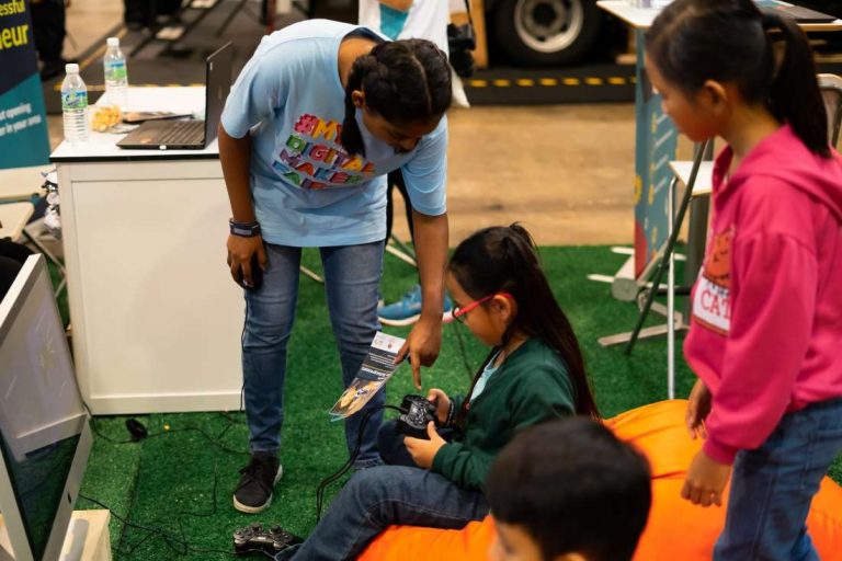 Children learning to use game console at the Malaysian Digital Fair.