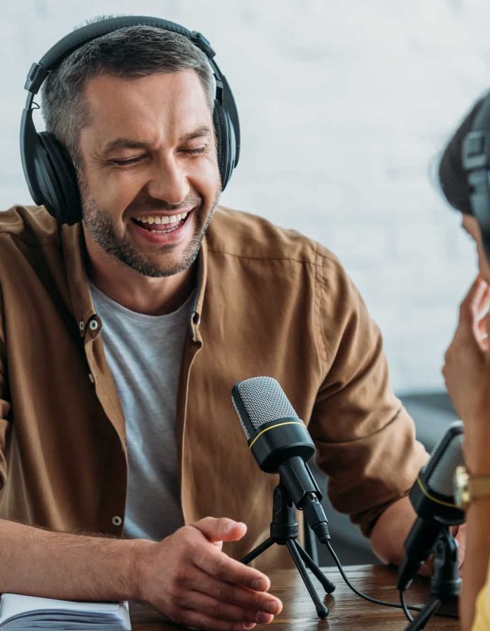 locutor de radio alegre riendo mientras graba podcast con un colega