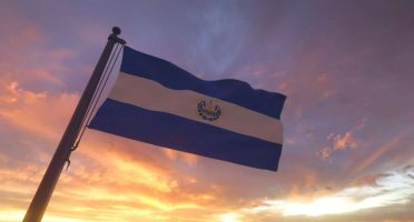 El Salvador Flag on Flagpole by Evening Sunset Sky