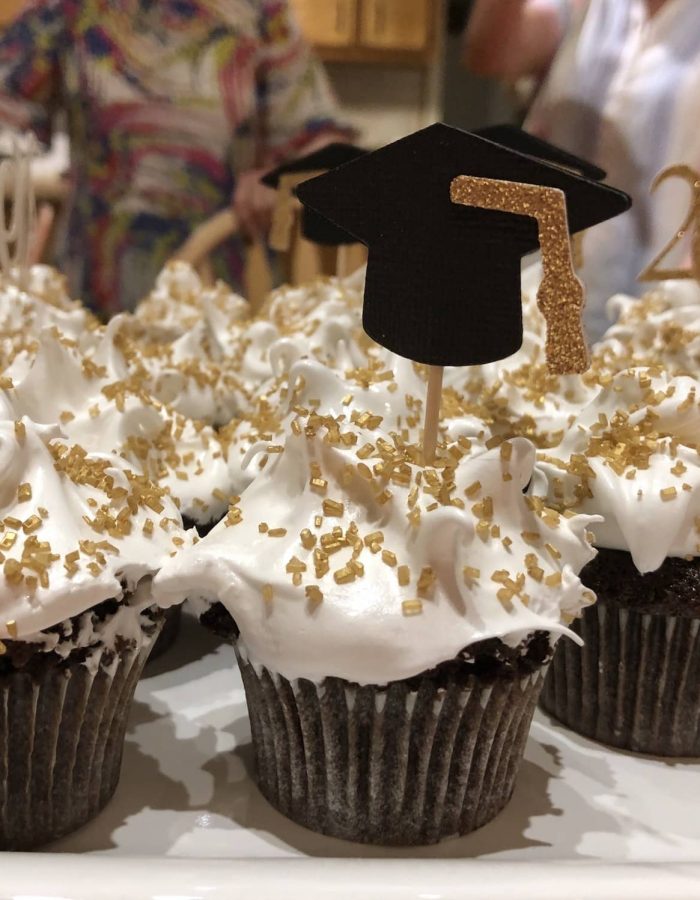 Celebración de graduación. Vista lateral de cupcakes con decoraciones de birrete.