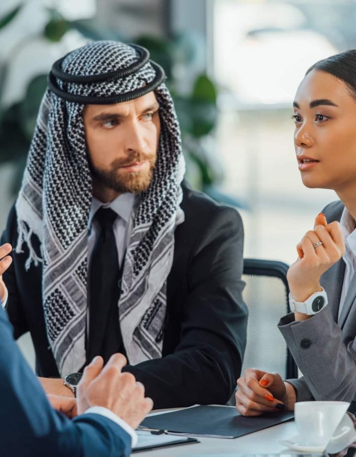 Socios de negocios multiculturales hablando de reunirse con el traductor en la oficina